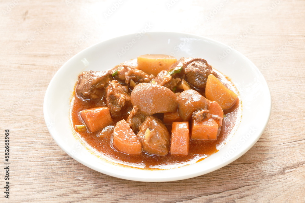 boiled pork leg with carrot in sweet red gravy sauce stew on plate