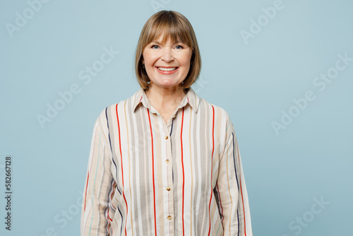 Photos Elderly smiling cheerful fun happy cool optimist woman 50s years old wearing light striped shirt looking camera isolated on plain pastel blue cyan color background studio portrait