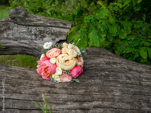 Bride s wedding bouquet of pink and white roses on natural background on tree stump in forest