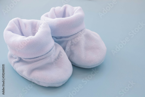 Blue booties for a boy on a blue background. Shoes for newborns