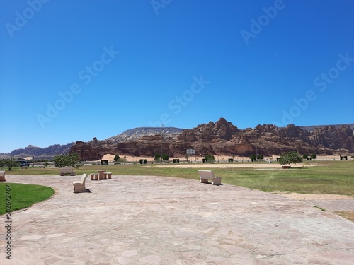 A beautiful daytime view of a winter park in Al-Ula, Saudi Arabia. The park is surrounded by ancient hills.