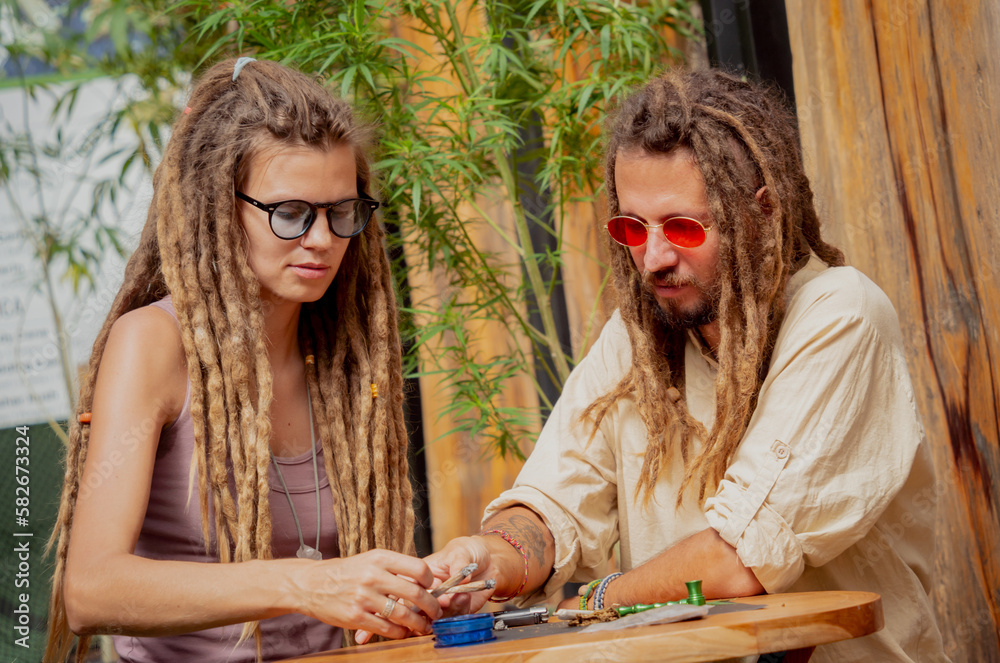 Fototapeta premium Hippie style couple smoking cigarettes with medical marijuana