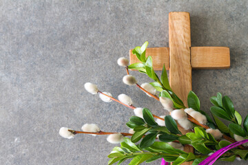 Wooden cross and easter palm tree made of catkins and boxwood, palm sunday concept 