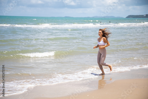 Woman running during outdoor s workout on summer beach