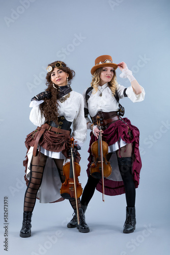 Country girls duet with violins on the grey background.