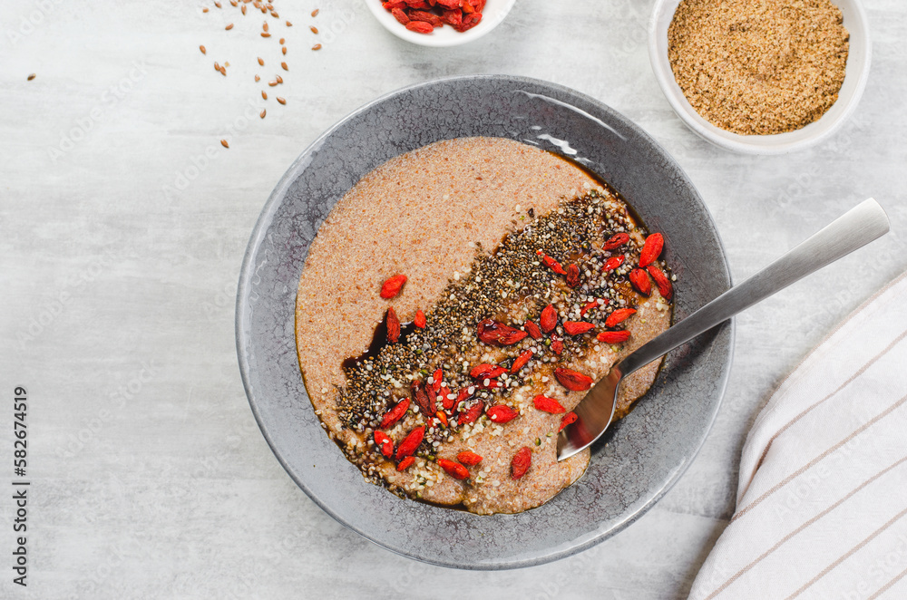 Flaxseed Porridge in a Bowl, Healthy Breakfast or Snack, Porridge Decorated with Chia Seeds and Goji Berries