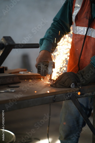 Working with Power Tools - Stock photo of Man Using Angle Grinder with Sparks Flying, Man using angle grinder sparks, Worker cutting metal with grinder 