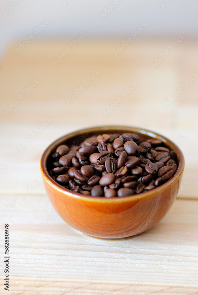 Fototapeta premium close-up of brown coffee beans in a bowl as mobile wallpaper, vertical mobile background, smartphone wallpapers, mobile wallpapers with coffee beans, coffee beans background, vertical use