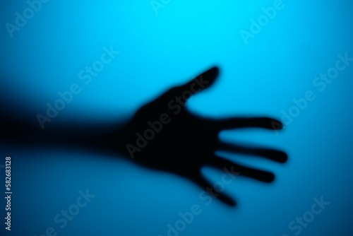 Silhouette of an open palm in neon light