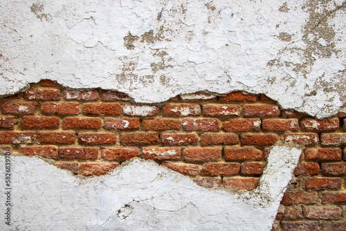 Deteriorated old orange brick wall