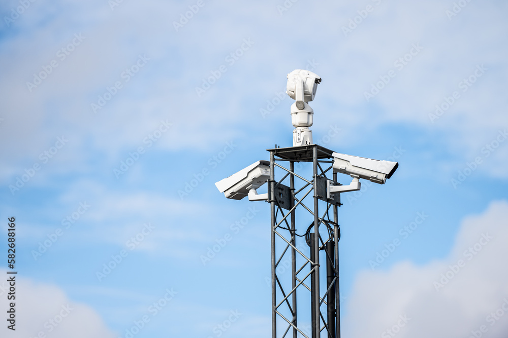 Traffic cameras on top of a pylon.