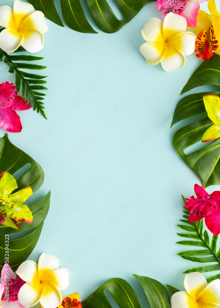 Summer background with tropical orchid flowers and green tropical palm leaves on light background. Flat lay, top view. Summer background with tropical orchid flowers and green tropical palm leaves on light background. Flat lay, top view.