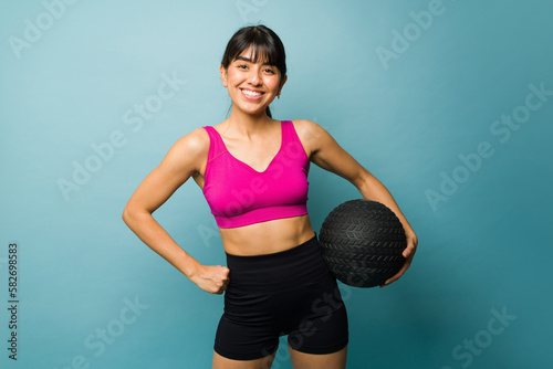 Smiling fitness trainer doing cross training with a slam ball © AntonioDiaz