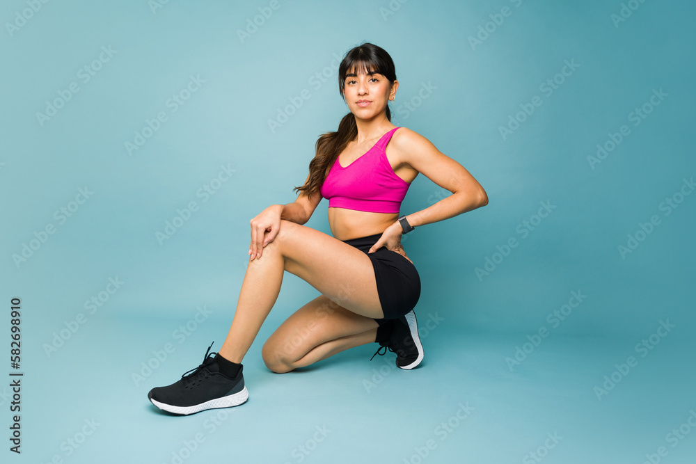 Gorgeous fitness trainer posing against a blue background