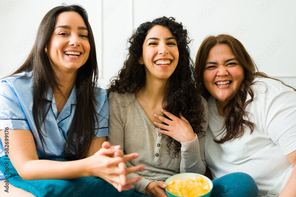 Cheerful best friends having a sleepover watching movies Cheerful best friends having a sleepover watching movies