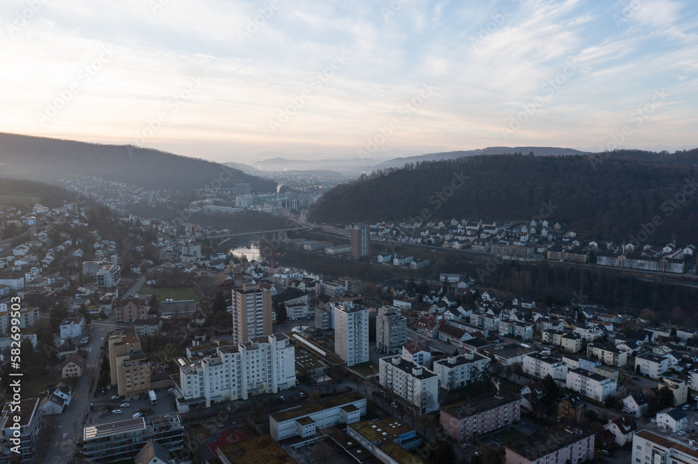 Fototapeta premium Great drone shot above the village called Nussbaumen with the city of Baden in the background in Switzerland.