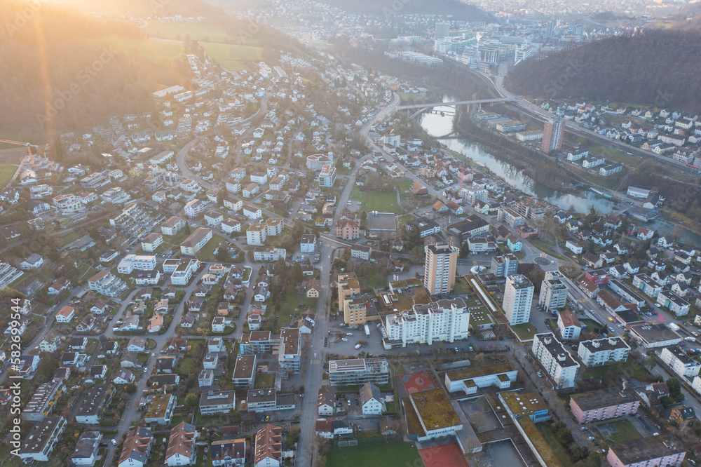 Naklejka premium Great drone shot above the village called Nussbaumen with the city of Baden in the background in Switzerland.
