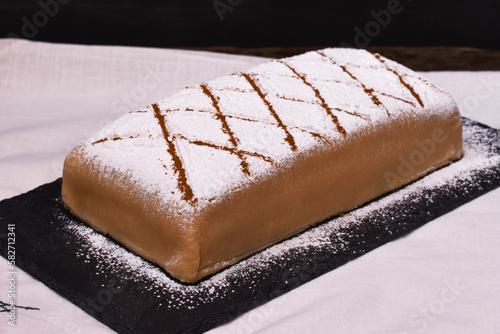 Tarta con capas de bizcocho y crema cubiertas de mazapán con azúcar glas por encima. Ponche segoviano, postre típico en Segovia, España.  photo