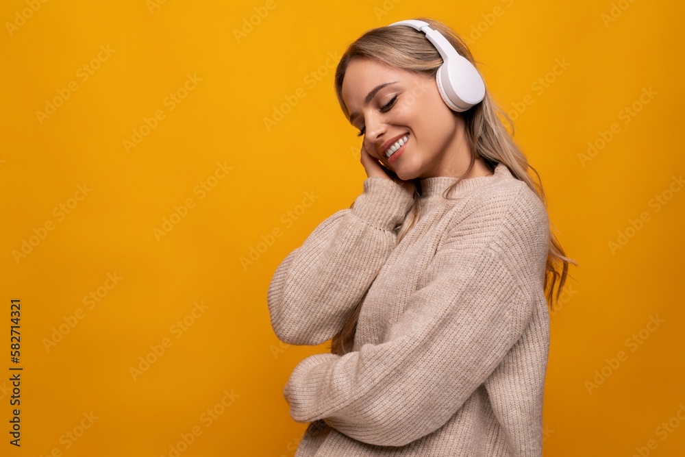 young student with big headphones among yellow studio background young student with big headphones among yellow studio background