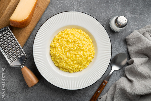 Traditional Italian dish Risotto alla milanese on a concrete background, top view