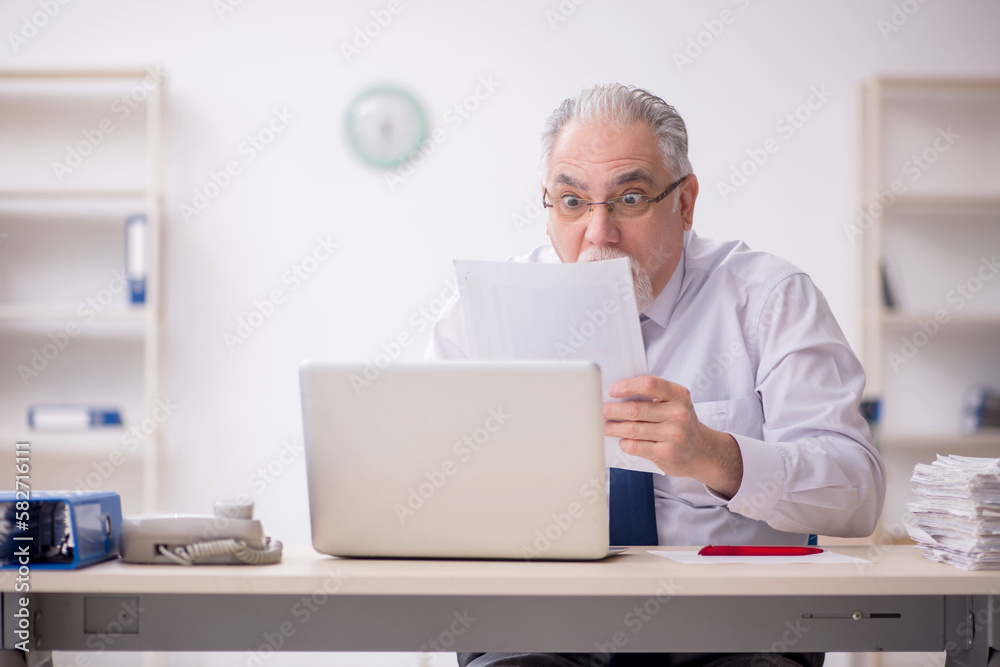 Old male employee working in the office Old male employee working in the office