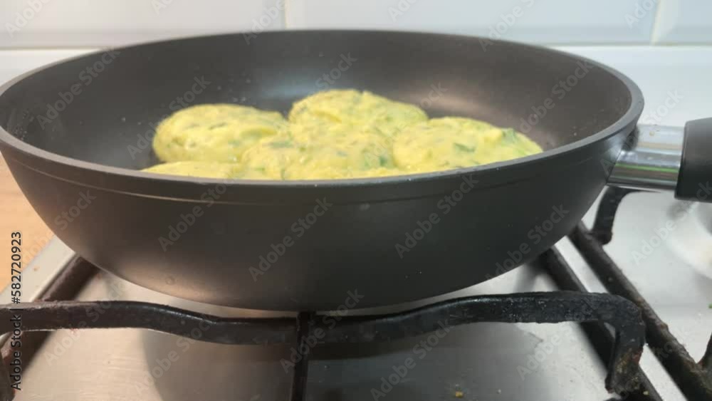 fried potato pancakes in a black pan, vegetarian food, the process of making potato pancakes fried potato pancakes in a black pan, vegetarian food, the process of making potato pancakes