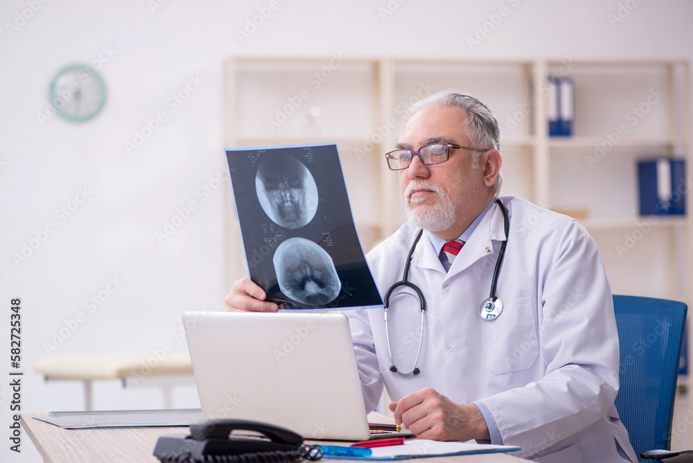 Old male doctor radiologist working in the clinic Old male doctor radiologist working in the clinic