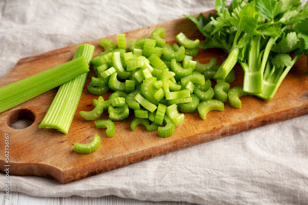 Raw Green Organic Celery on a rustic wooden board, low angle view. Raw Green Organic Celery on a rustic wooden board, low angle view.