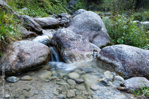 Landscape of a mountain river on a long exposure. The river in the passage gorge is not far from the city of Almaty. A beautiful stormy river with clear water. photo