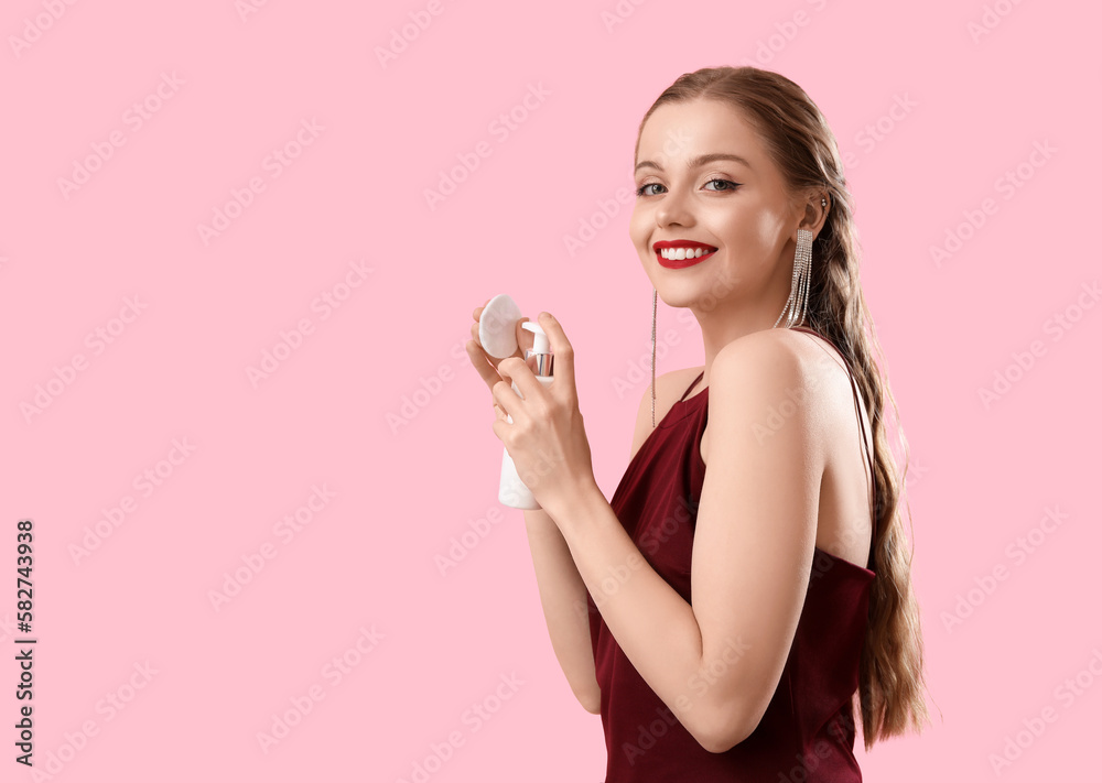 Young woman with cotton pad and makeup remover on pink background Young woman with cotton pad and makeup remover on pink background