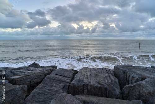 Sea against a cloudy sky with huge rocks in the foreground in Ventnor, Isle of Wight, England photo