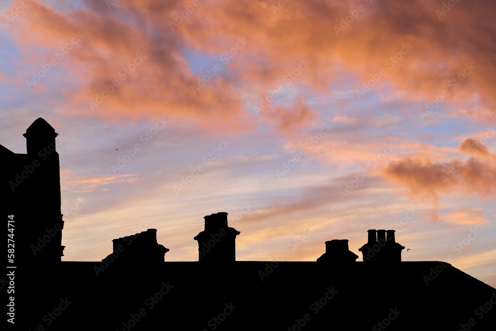 Roof of a building in a shadow during scenic pink sunset