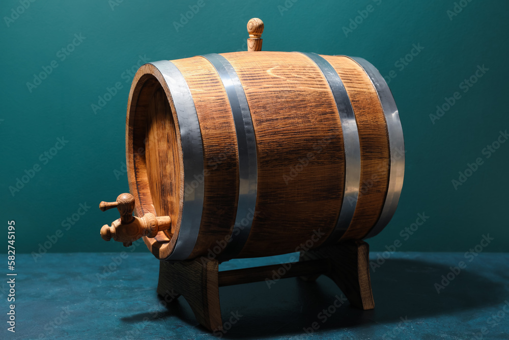 Wooden barrel on table near green wall