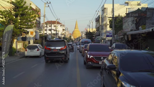 Phra Pathommachedi temple. The golden buddhist pagoda with residential houses, urban city of Nakorn Pathom district, Thailand. Holy Thai architecture.