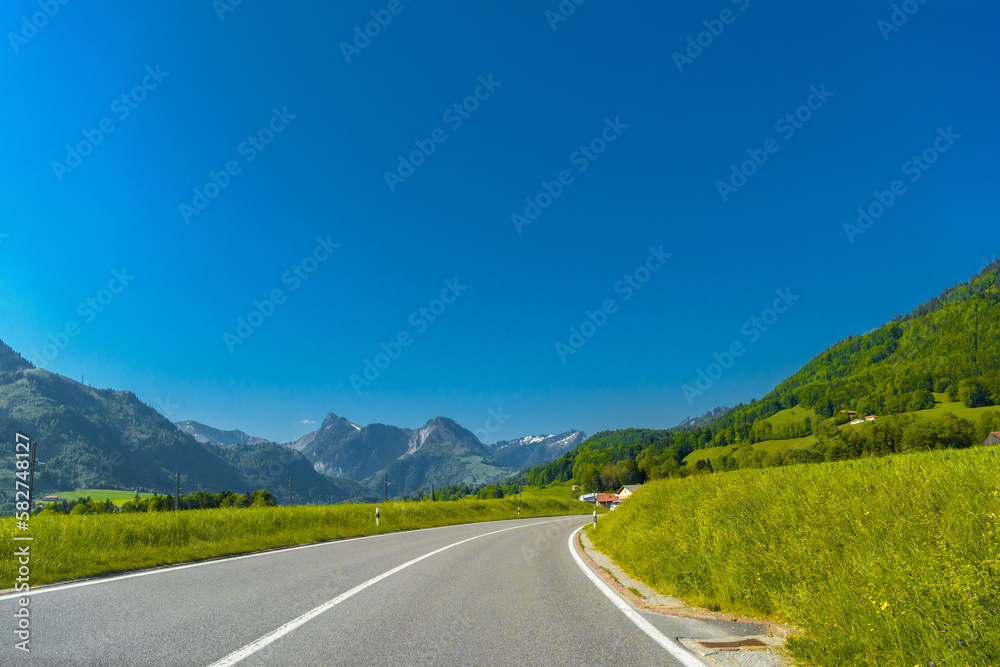 Road with green meadows and moutains near Haut-Intyamon, Gruyere, Fribourg Switzerland