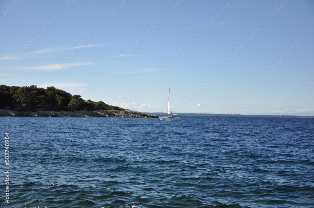 Sailboat in the rough sea with horizon line in background. Island Losinj touristic and yacht destination on Adriatic Sea. Sailboat in the rough sea with horizon line in background. Island Losinj touristic and yacht destination on Adriatic Sea.