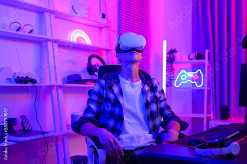 Young Caucasian man Pro Gamer have live streaming playing video game, using virtual reality glasses at home