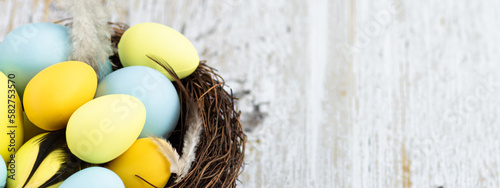 Photography Stylish background with colorful easter eggs on white wooden background with cop