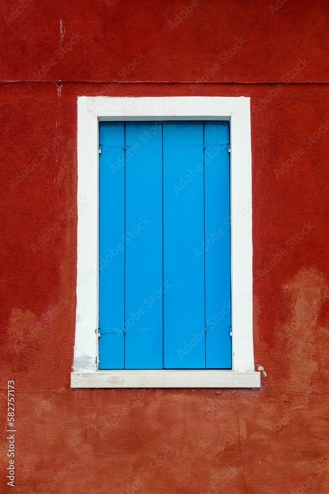 Blue window of red building in Venice