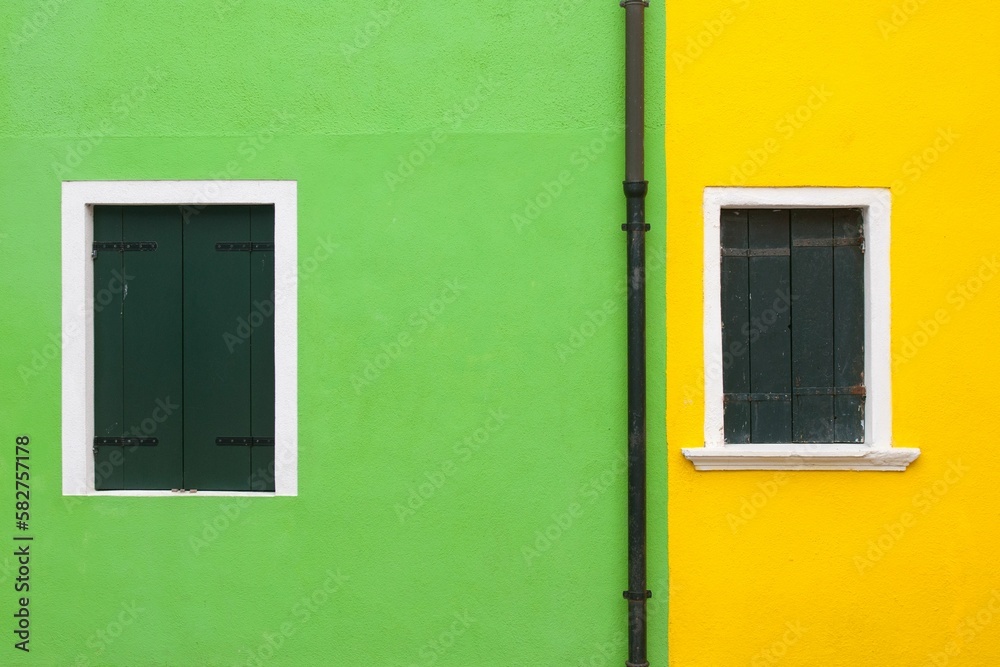 Closeup of windows of yellow and green building in Venice
