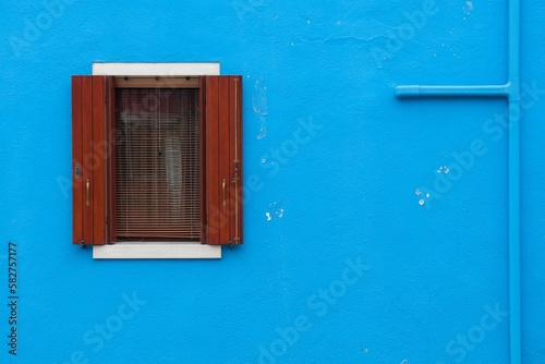 Red window of blue building in Venice