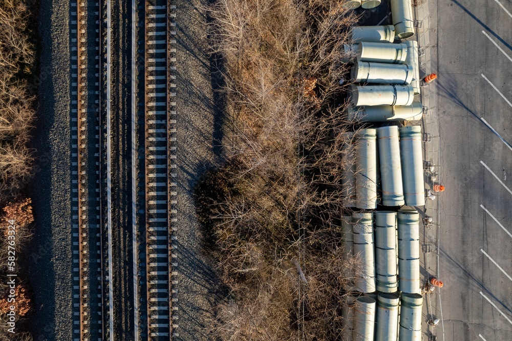 Obraz premium Aerial shot of train tracks with construction pipes and tubes
