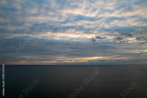 Aerial view of the seascape under cloudy dusk sky at sunset