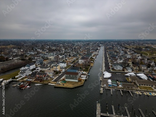 Aerial shot over a small marina with a wooden pier and a few boats in Hewlett, New York