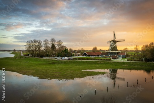 Scenic view of an old windmill with reflection on the water surface in the countryside