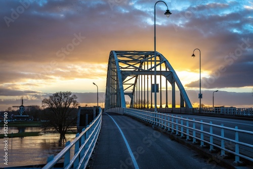 Fototapeta Naklejka Na Ścianę i Meble -  Scenic view of a bridge over a river during sunset