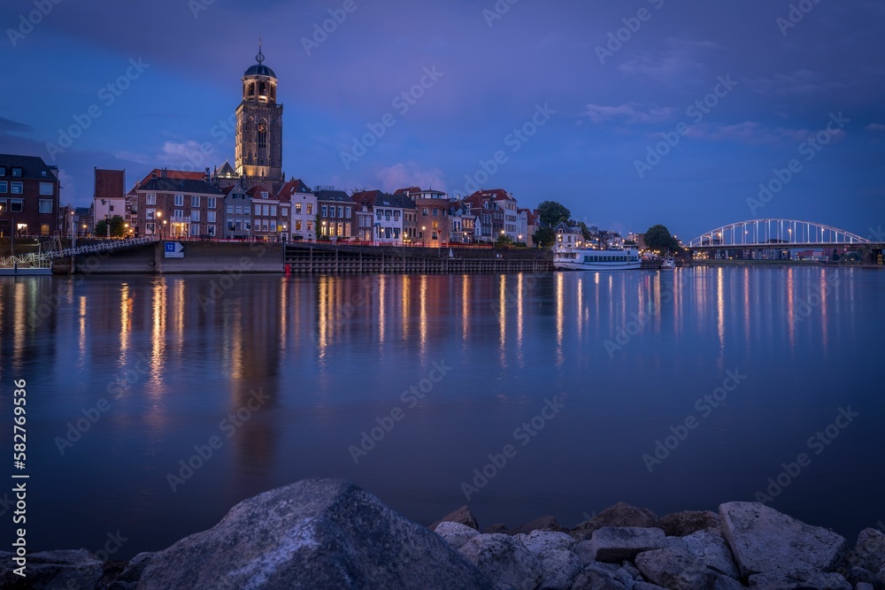 Cityscape of the river city Deventer, Netherlands with a view of St Lebuinus church at night