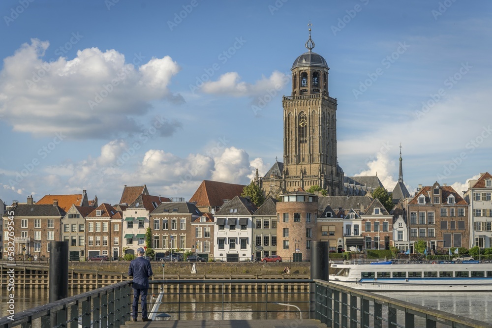 Man sightseeing the St Lebuinus protestant church and the cityscape of Deventer, Netherlands