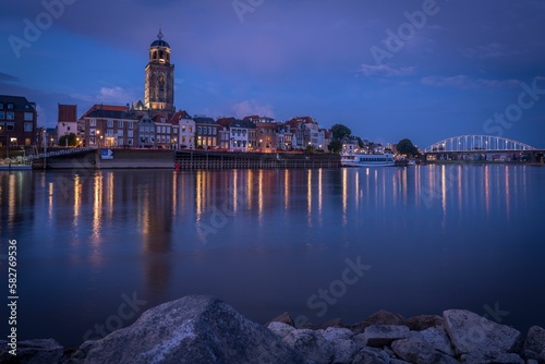 Cityscape of the river city Deventer, Netherlands with a view of St Lebuinus church at night