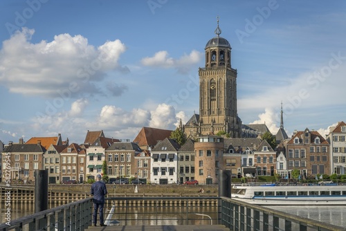 Man sightseeing the St Lebuinus protestant church and the cityscape of Deventer, Netherlands